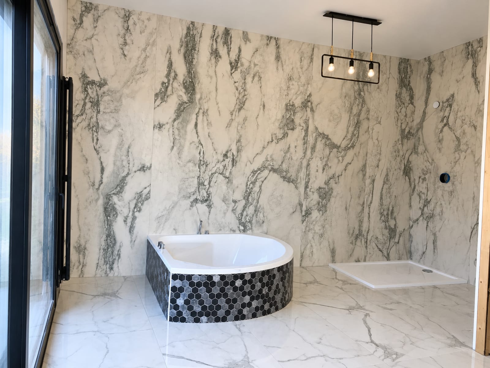 Salle de bain en carrelage effet marbre avec baignoire d'angle